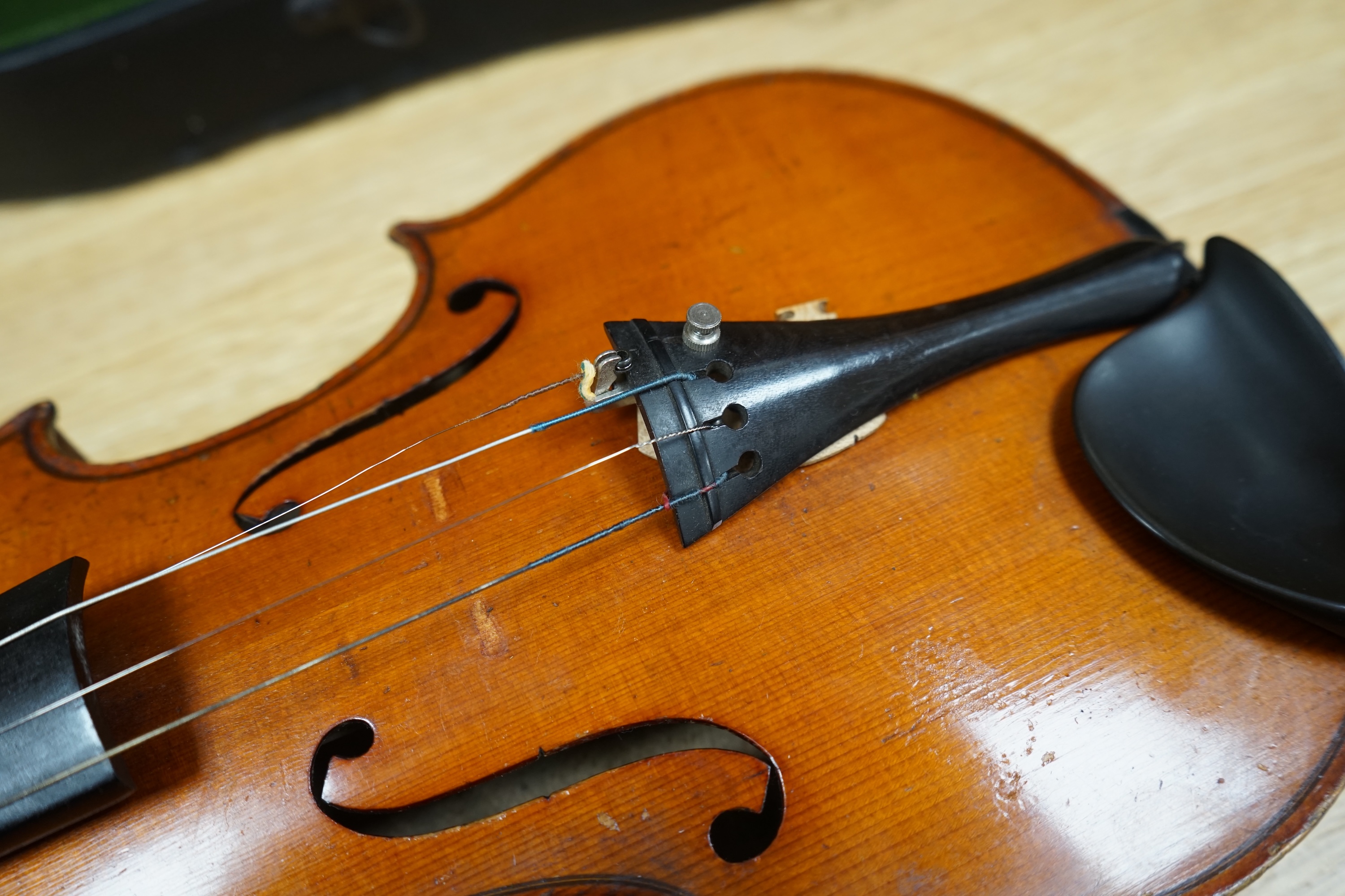 A cased early 20th century violin with bow, no label, back measures 35.5cm. Condition - fair to good